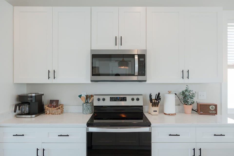 Modern fully equipped kitchen with stainless steel appliances, cookware, dishes, and all the essentials needed for cooking and entertaining.