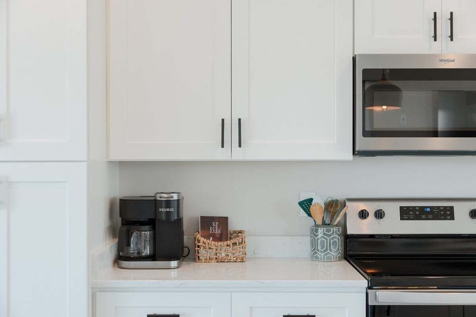 Modern fully equipped kitchen with stainless steel appliances, cookware, dishes, and all the essentials needed for cooking and entertaining.