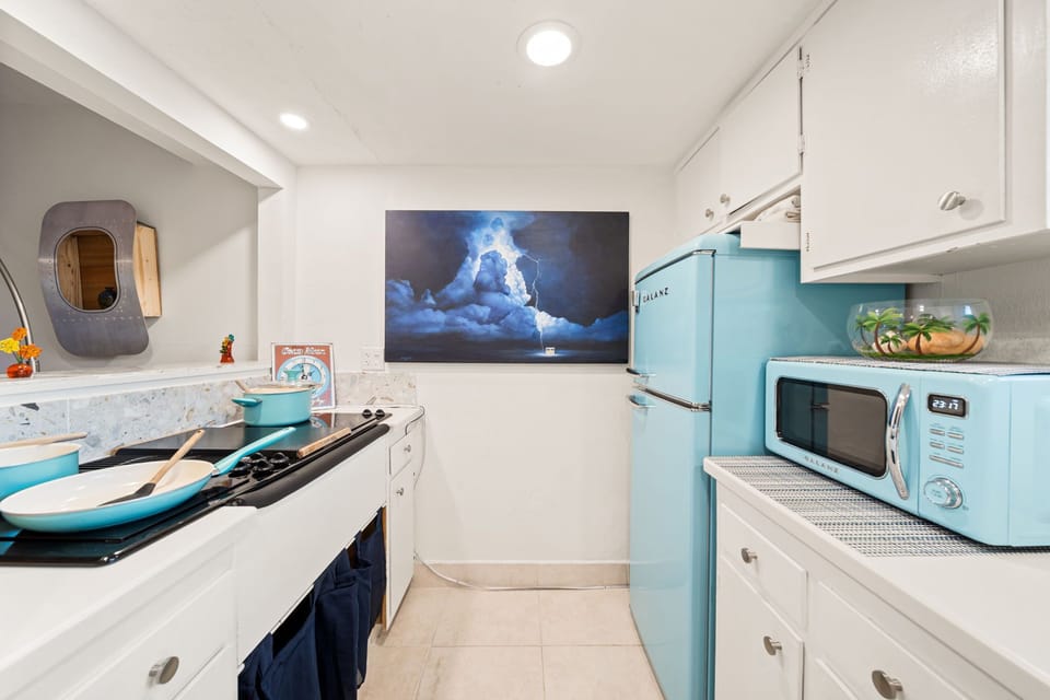 Kitchen is equipped with blue-themed appliances and equipment.