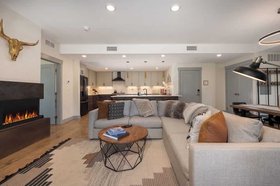 - Relax in this open concept living space with a plush sectional and modern finishes - Kitchen behind features bar seating, stainless appliances, and sleek cabinetry - Perfect layout for cooking, lounging, and connecting with your group