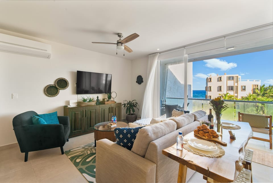 Cozy living room with sofa bed opens to balcony with ocean views.