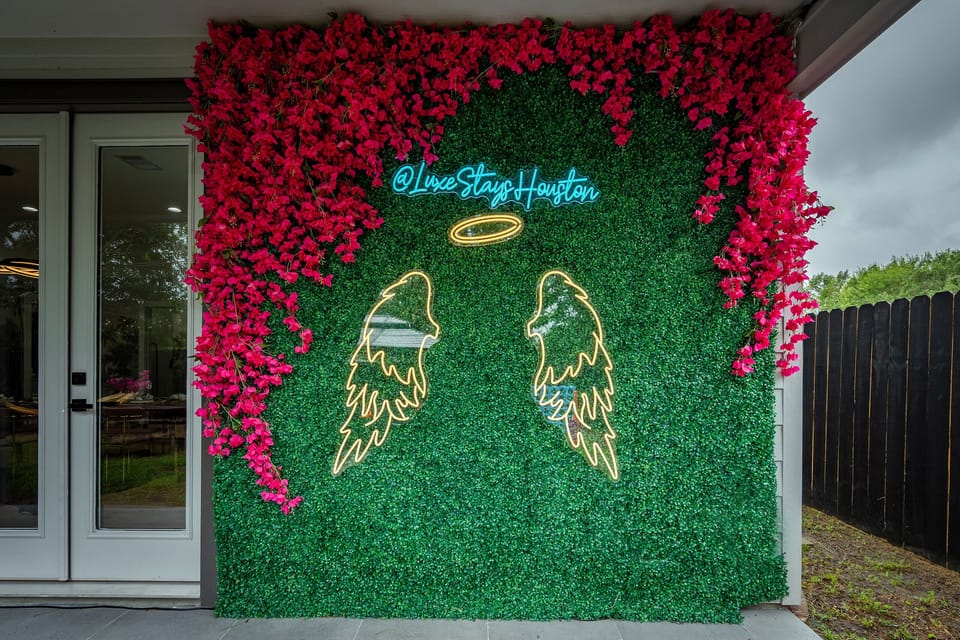 Vibrant Outdoor Oasis: Snap selfies by our stunning floral wall and neon accents!