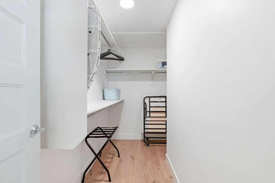 Walk in closet with luggage rack and rollaway cot
