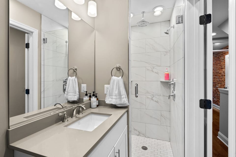 Hallway bath shower and sink. Bathroom comes with rainfall shower head.