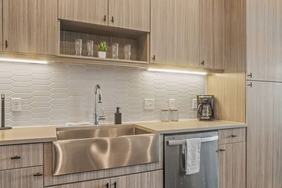 This contemporary kitchen is a chef's dream, featuring a large island, modern stainless steel appliances, and sleek cabinetry. The open layout ensures you can cook and entertain effortlessly, making it the perfect space for culinary creativity and social