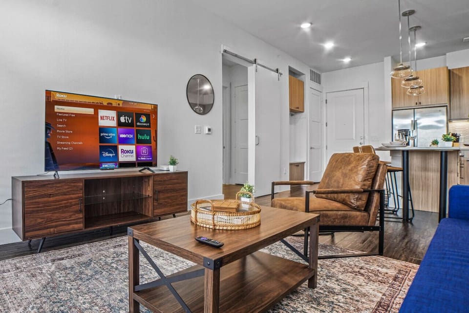Bright and airy living room with plush seating, a large TV, and tasteful decor, creating the perfect space for relaxation and entertainment.