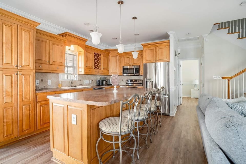 Spacious kitchen with warm wood cabinetry and breakfast bar seating