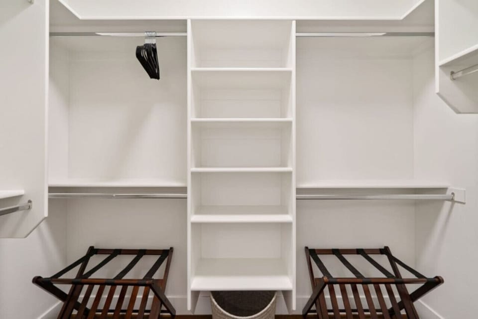 Walk-in closet with hangers and luggage racks