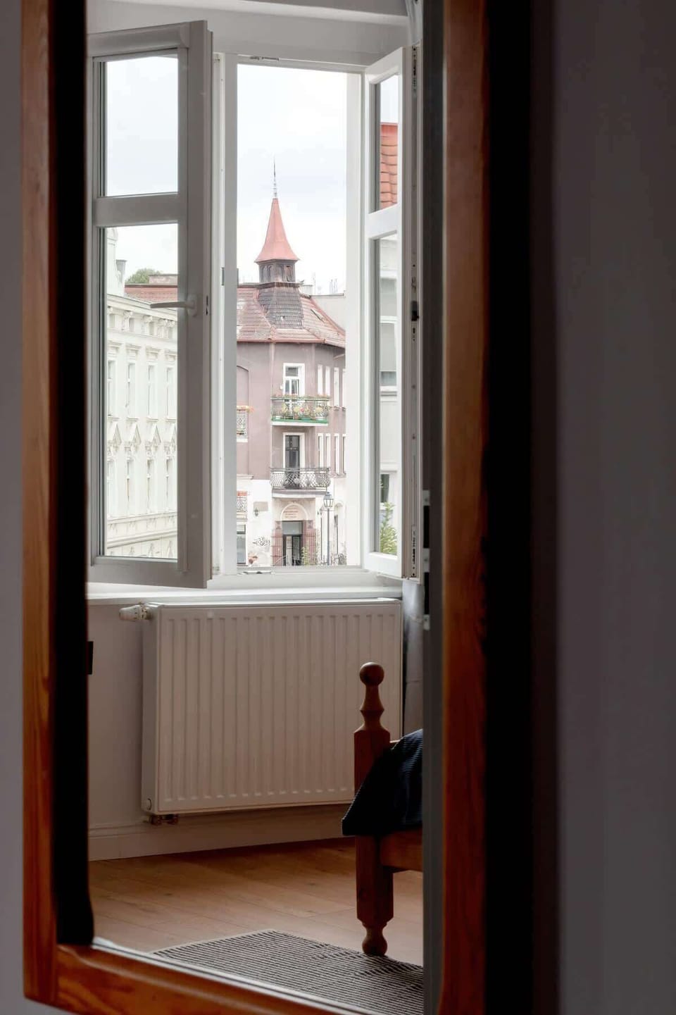 A narrow corridor with a view of the church tower.