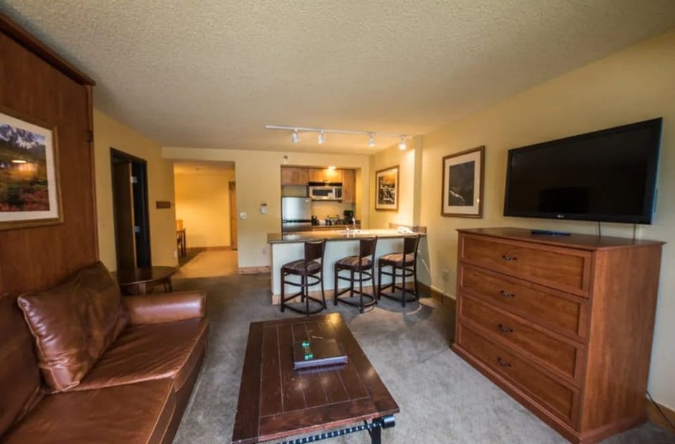 Comfortable living area with ample seating and a flat-screen TV, perfect for relaxing evenings.
