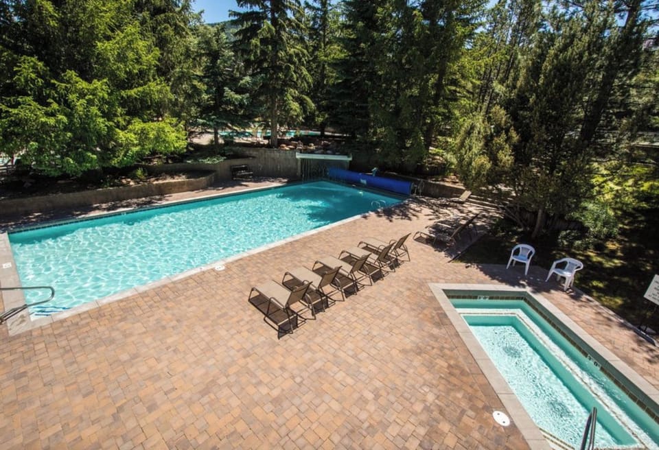 Enjoy the spacious outdoor pool and hot tub surrounded by beautiful mountain greenery.