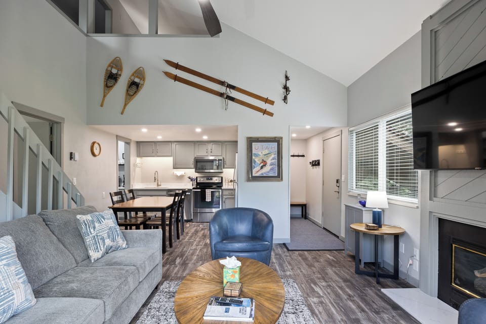 Open-concept main living space connecting the living room, dining area, and kitchen, offering a welcoming layout with vaulted ceilings and great flow for groups.