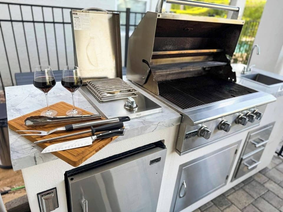 🍽️ Outdoor Chef’s Kitchen! Grill in style with a 32” pro-grade BBQ, side burner, beverage fridge & sink — fully equipped with all utensils for unforgettable alfresco dining.