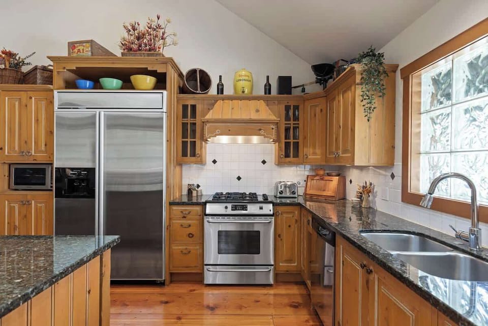 - Modern kitchen featuring stainless steel appliances and polished granite countertops for easy vacation cooking  
- Surrounded by warm wood cabinetry and large windows with snowy views  
- Perfect setup for group breakfasts or cozy dinners after the