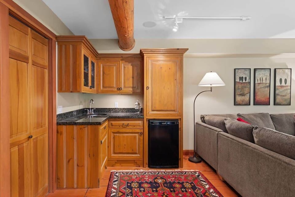 - Convenient kitchenette with wood cabinets and mini fridge for quick snacks  
- Perfect for game nights or lower-level entertaining  
- Warm lighting adds charm to this comfortable space  
