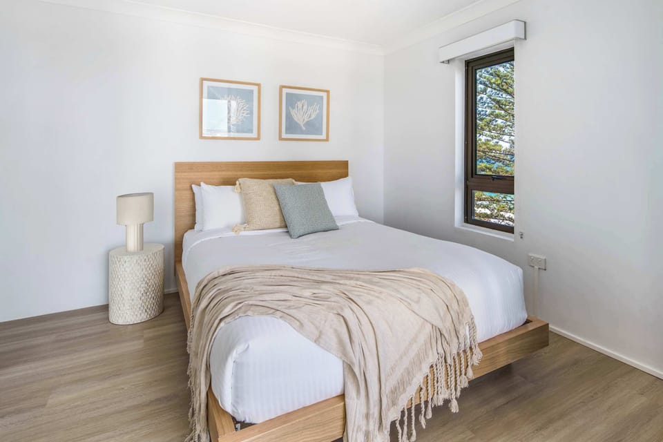 Bedroom 2, featuring a plush Queen bed and back balcony access