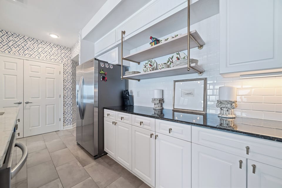 This fully functional kitchen boasts stainless steel appliances, sleek countertops, a decorative backsplash, and ample cabinet storage, ideal for everyday cooking and entertaining.