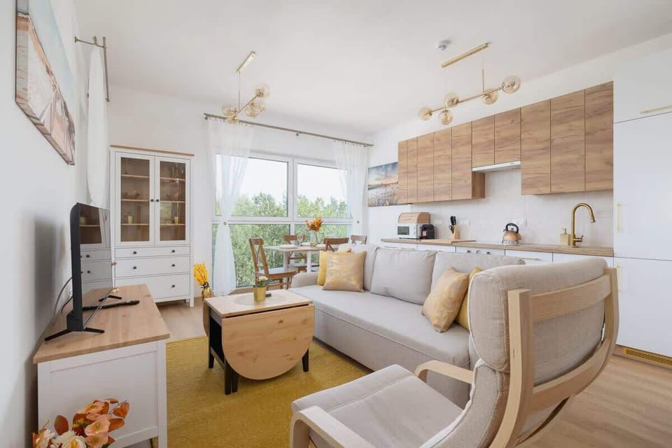 Bright and open living area with a neutral palette, clean lines, and wooden details, connected to a dining space for an airy and cohesive look.