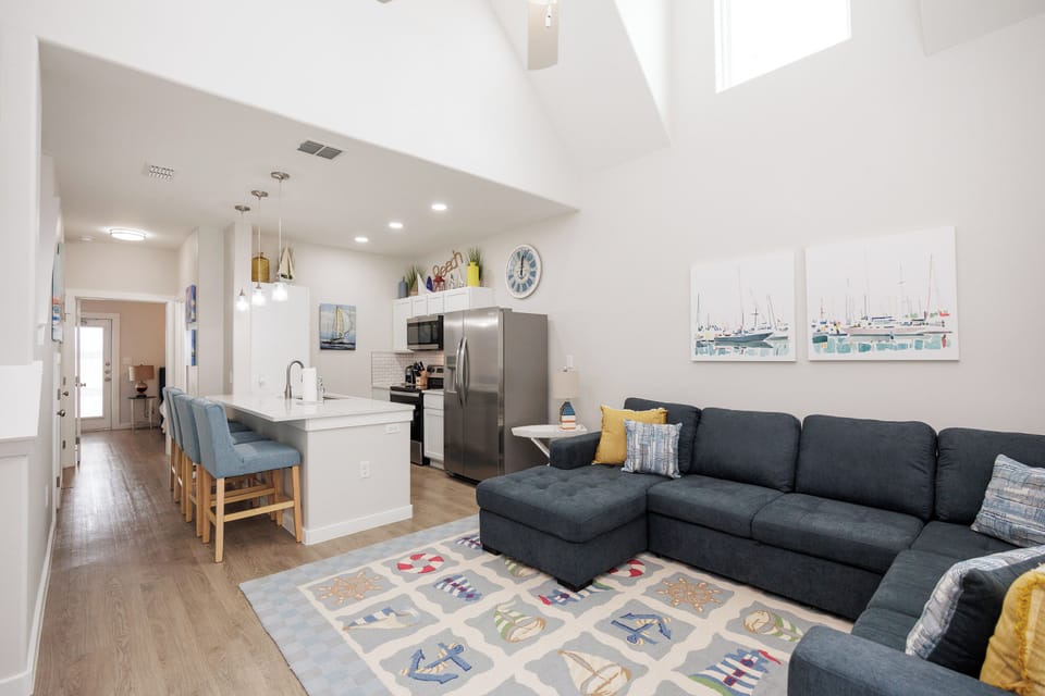 Unwind in your bright, open living space where coastal charm meets modern comfort with high ceilings and stylish furnishings.