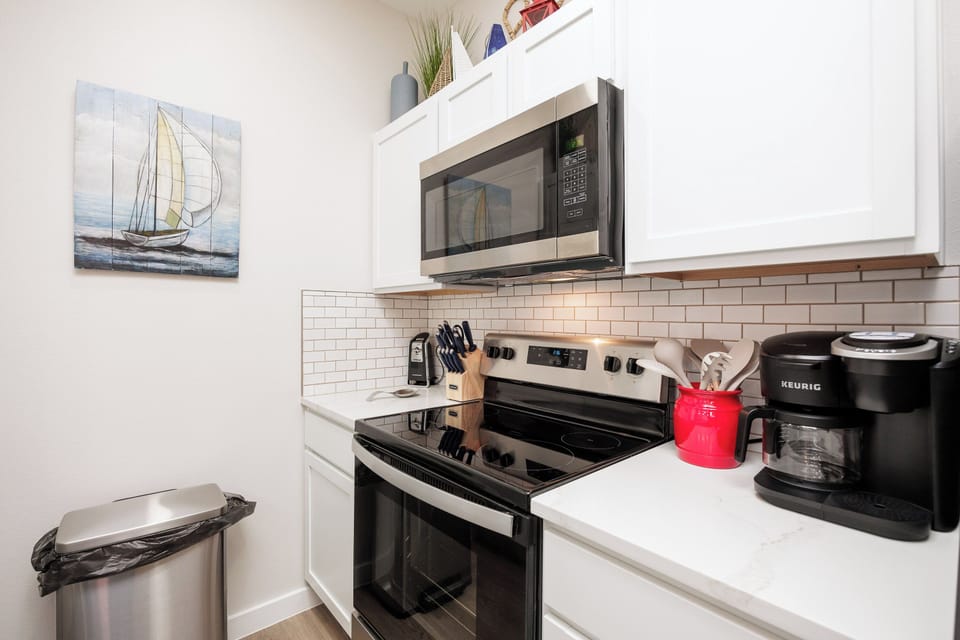 Your fully equipped kitchen awaits with stainless steel appliances, quartz countertops, and everything needed for home-cooked meals.