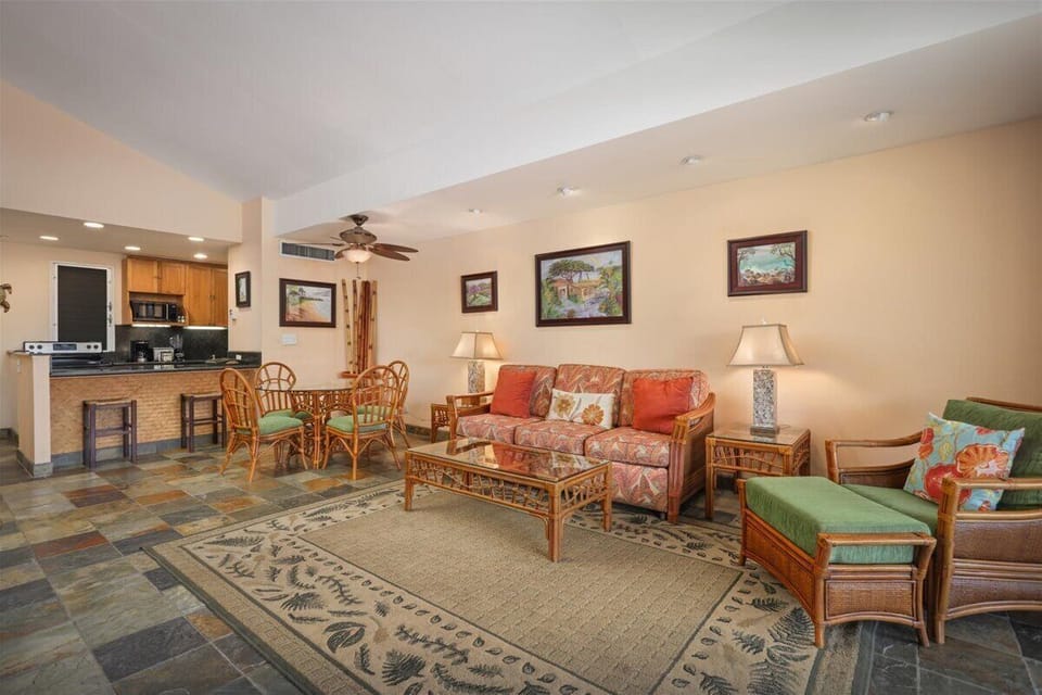 Relax in your spacious living area with tropical-style furnishings, vaulted ceilings, and an open layout connecting to a full kitchen—perfect for unwinding after island adventures.