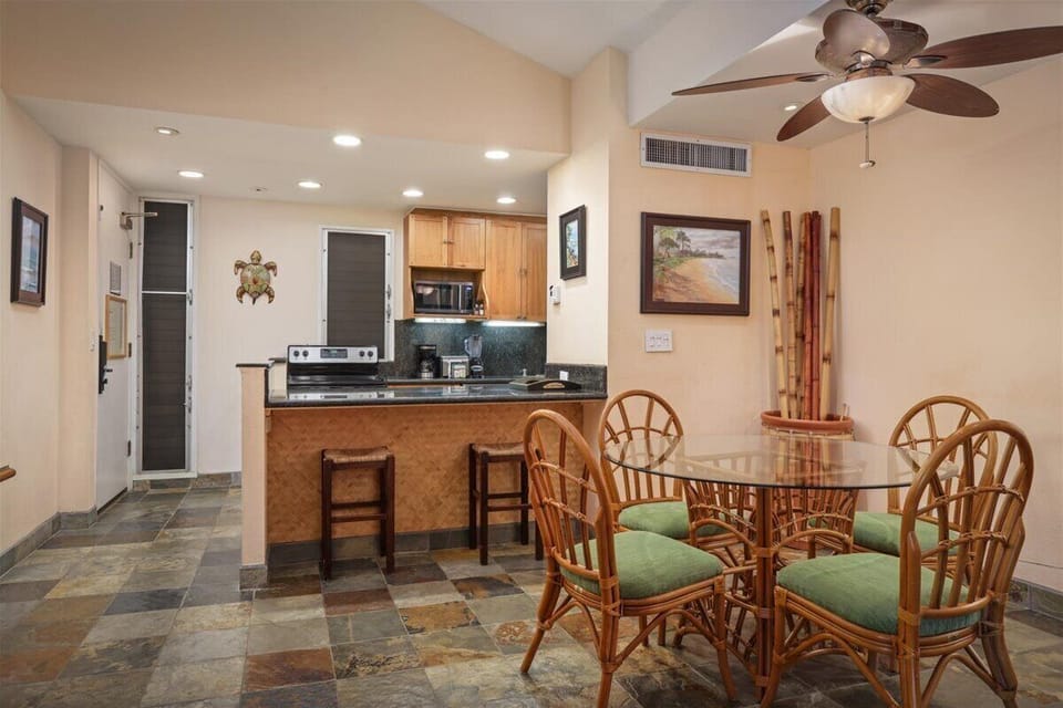 Your island-inspired retreat features an open kitchen and dining space where you can savor morning coffee at the breakfast bar or gather around the glass-top table for meals together.