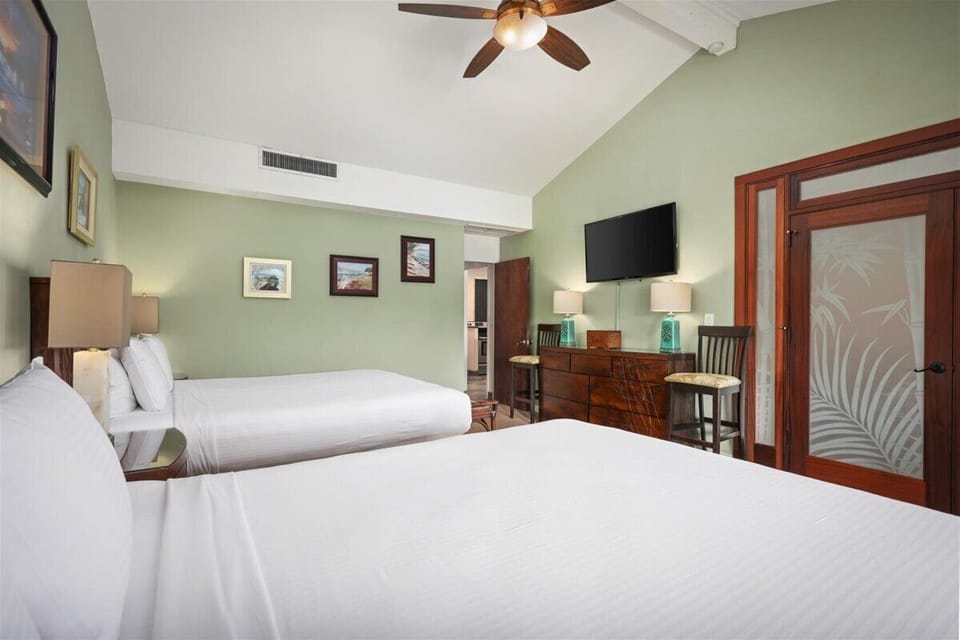 Unwind in your peaceful bedroom with plush beds, soothing sage walls, and gentle ceiling fan breezes. A smart TV and cozy seating ensure comfort after island adventures.
