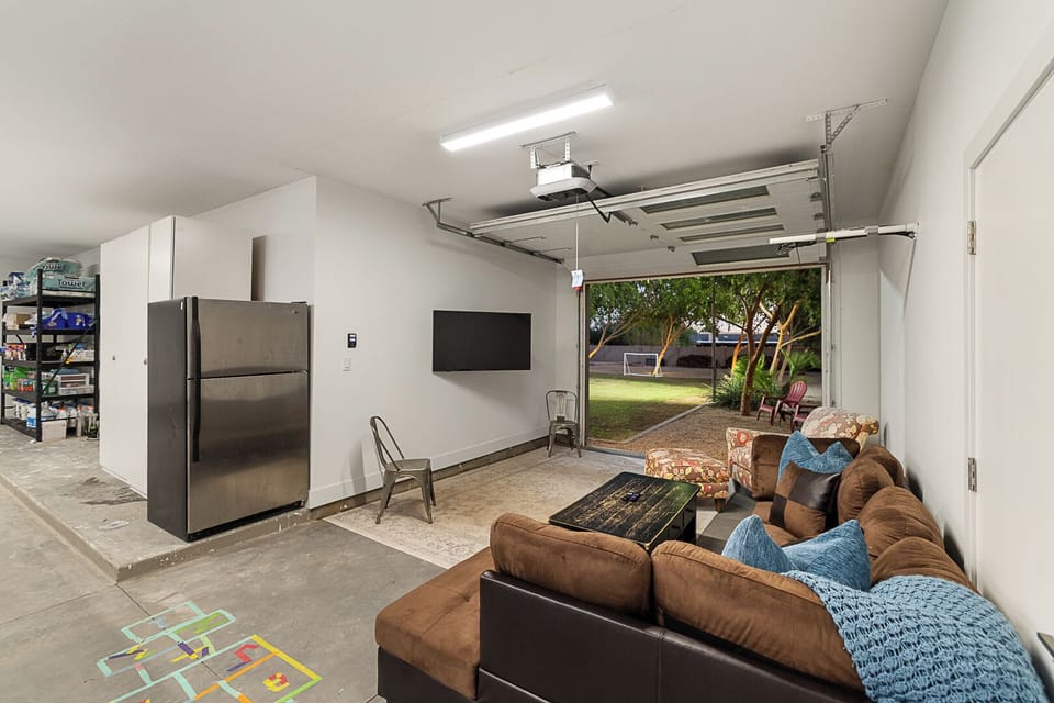 Casual hangout with sectional, TV, fridge & direct backyard access.
