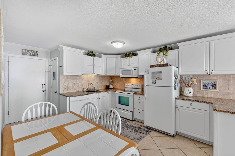 Dining Area - Enjoy meals together in the inviting dining space — with room for four plus bar seating for three more
