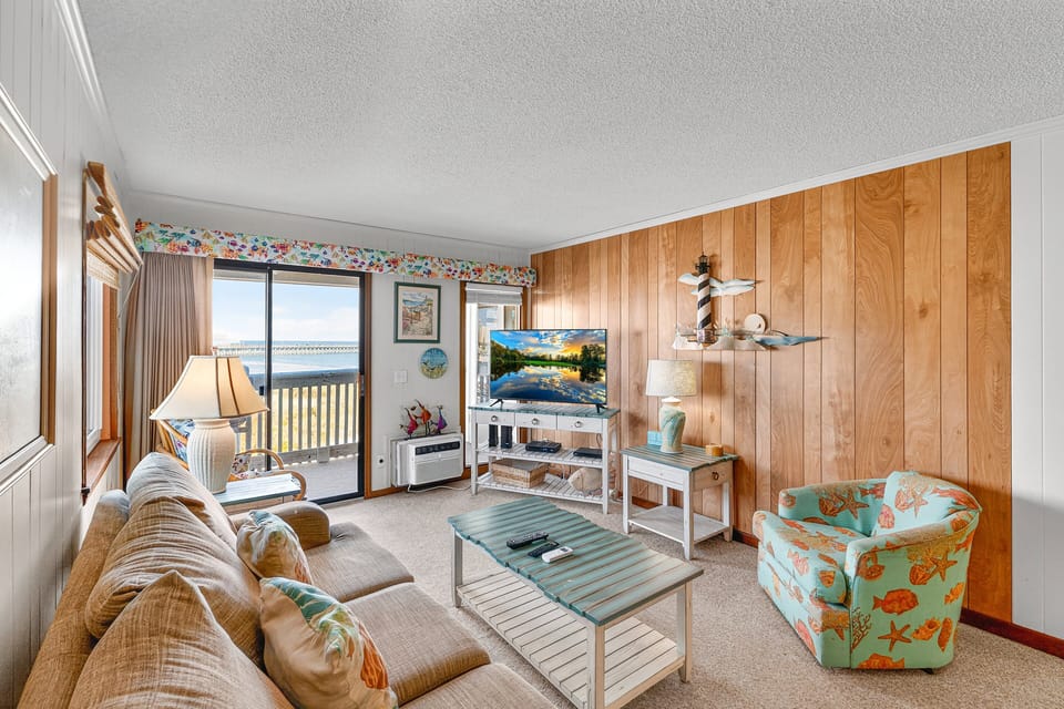 Living Room - Relax in this welcoming living area with comfortable seating and natural light, offering direct views of the beach and easy access to the balcony.