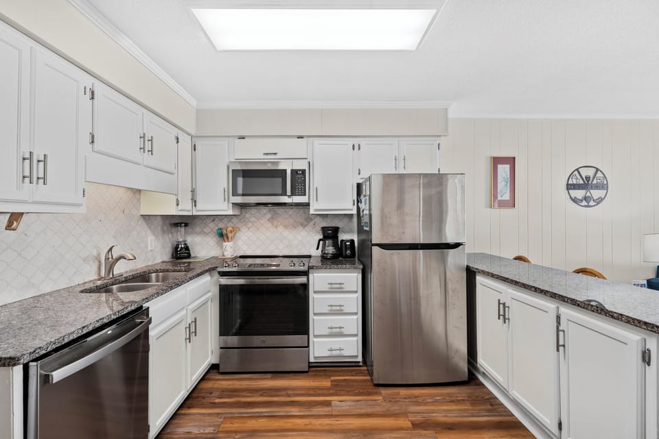 Kitchen - Kitchen with appliances including a stove, refrigerator, microwave, and dishwasher along with cookware for preparing meals.