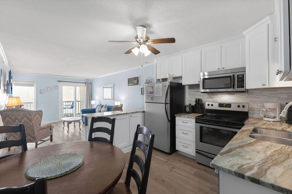 Kitchen - Kitchen with appliances including a stove, refrigerator, microwave, and dishwasher along with cookware for preparing meals.
