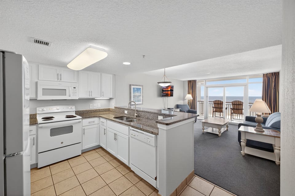 Kitchen - Prepare meals easily in the fully equipped kitchen with modern appliances, cookware, and breakfast bar space.