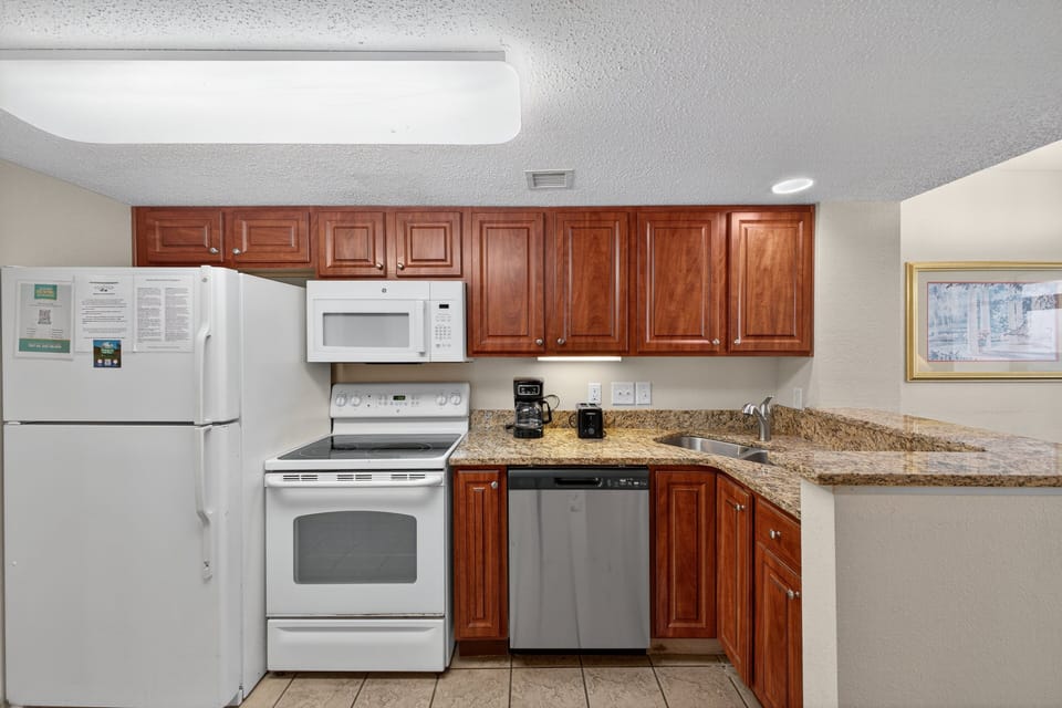 Kitchen - Prepare family meals in the fully equipped kitchen with stove, oven, refrigerator, dishwasher, and essential cookware.
