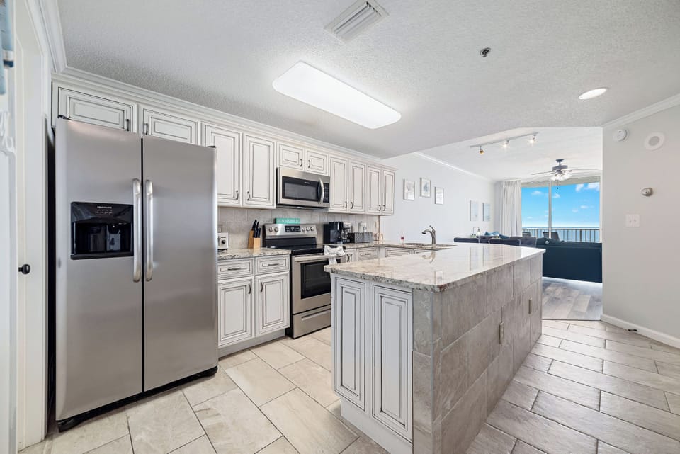 This fully functional kitchen boasts stainless steel appliances, sleek countertops, a decorative backsplash, and ample cabinet storage, ideal for everyday cooking and entertaining.