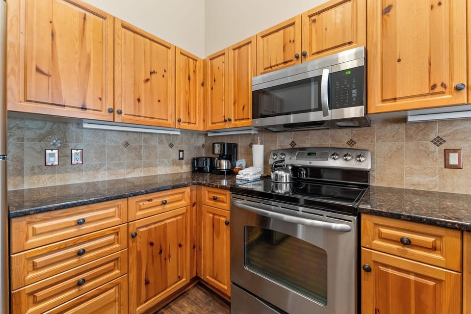 Your fully equipped kitchen features warm wood cabinets, granite countertops, and stainless steel appliances for all your culinary adventures.