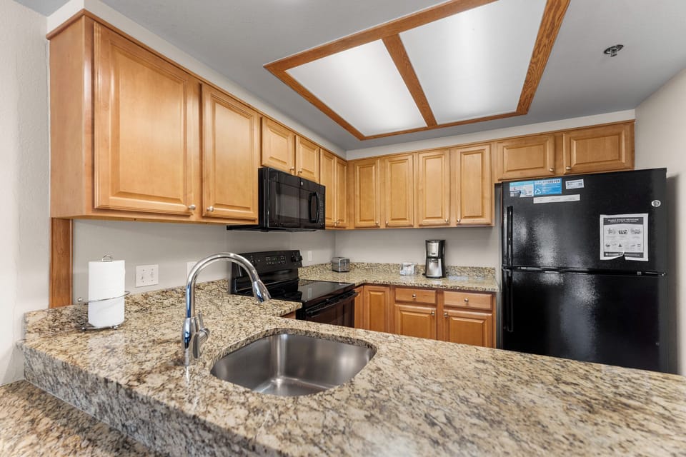 Your fully equipped kitchen features granite countertops, warm wood cabinetry, and everything you need to create memorable meals during your stay.