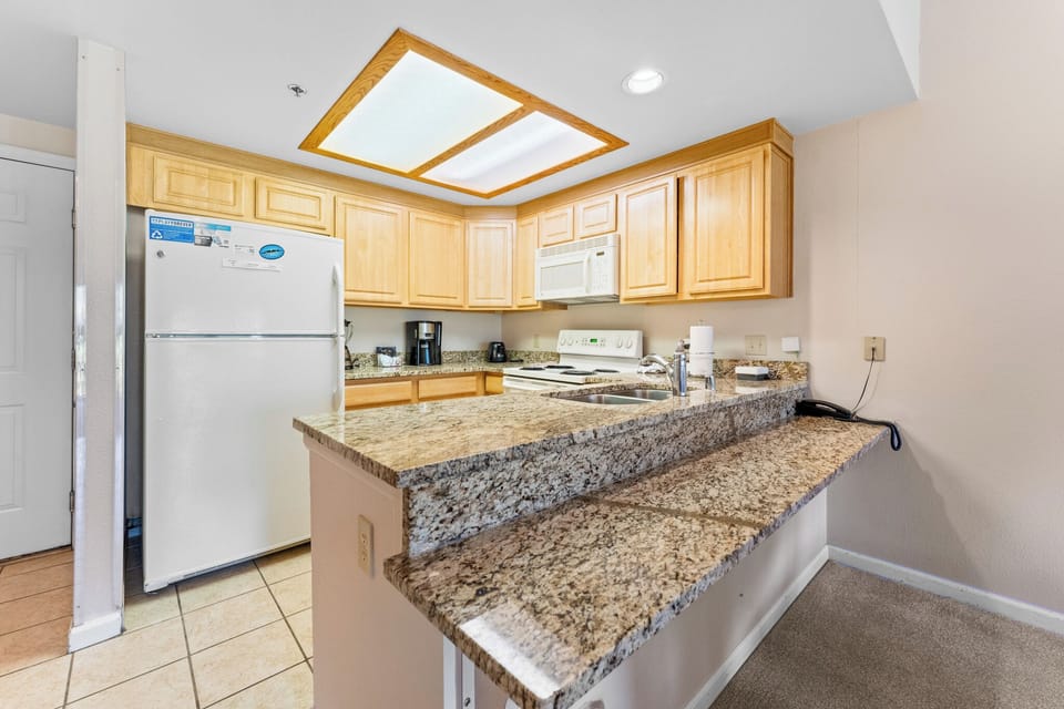 Your fully equipped kitchen features granite countertops, warm wood cabinets, and modern appliances for all your culinary adventures.