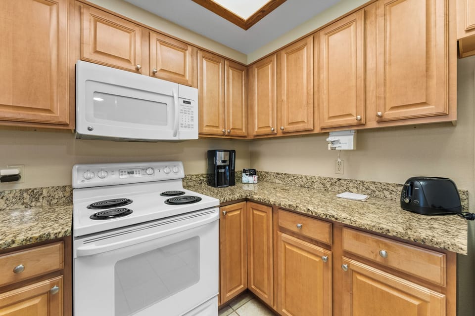 Your fully equipped kitchen features granite countertops, warm wood cabinetry, and everything you need to prepare memorable meals during your stay.