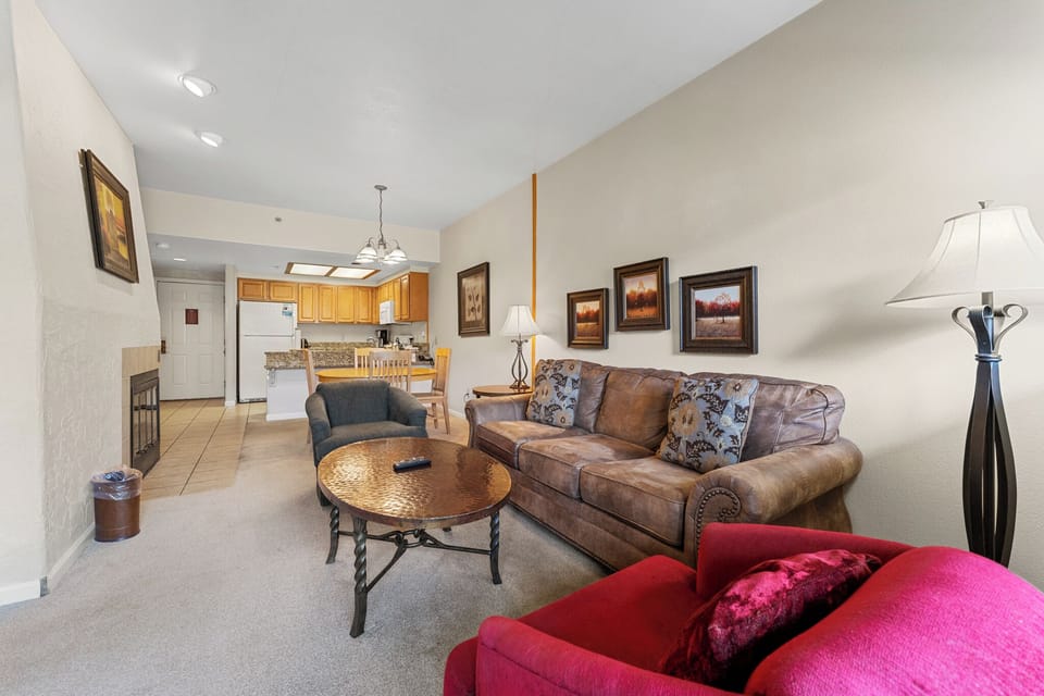 Unwind in your spacious living area featuring plush leather seating, warm lighting, and an open kitchen—perfect for relaxing after mountain adventures.