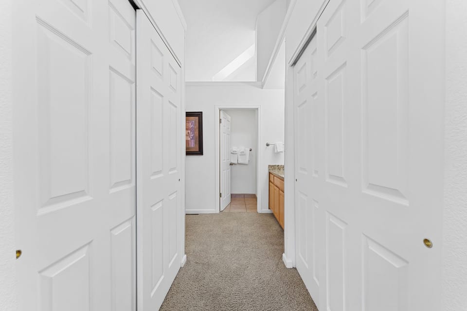 Step into your bright, welcoming hallway where crisp white walls and soft carpet guide you to your kitchen and bathroom spaces.