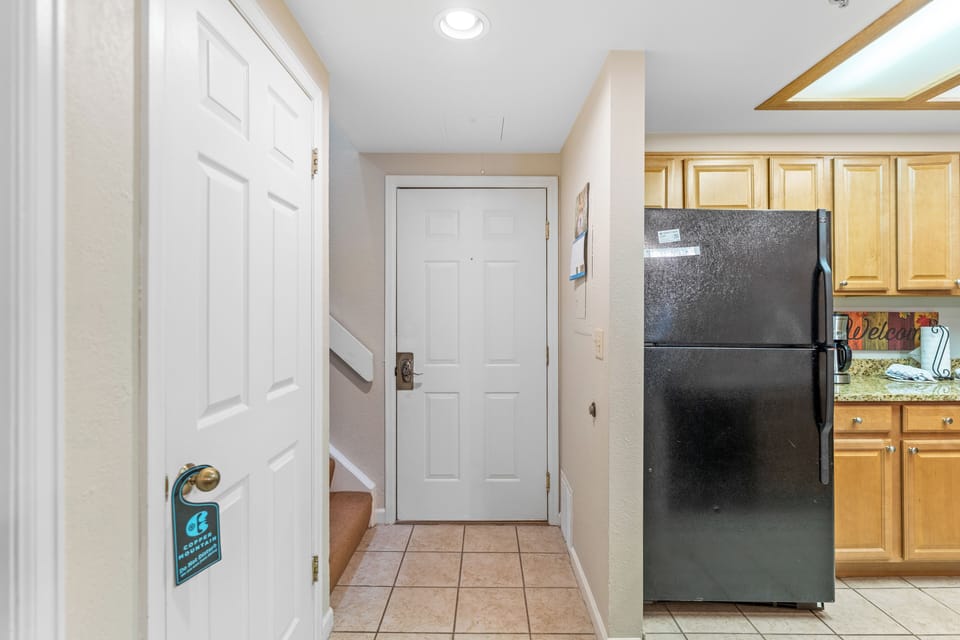 Step into your well-appointed kitchen with full-size appliances and warm wood cabinetry, perfect for preparing home-cooked meals during your stay.