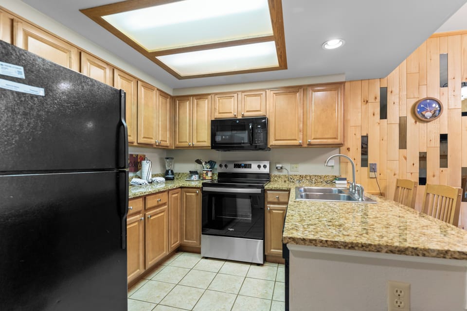 Your fully equipped kitchen features granite counters, stainless steel appliances, and a beautiful skylight that fills the space with natural light.