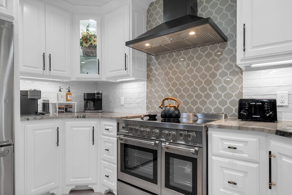 This elegant kitchen boasts sleek countertops, modern appliances, and stylish cabinetry. It has all the essentials for your cooking and dining needs.