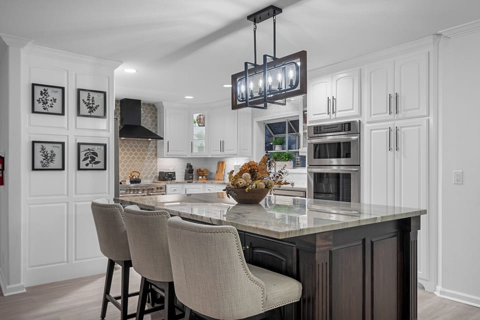 Sleek and fully equipped kitchen with a spacious island and seating for three.