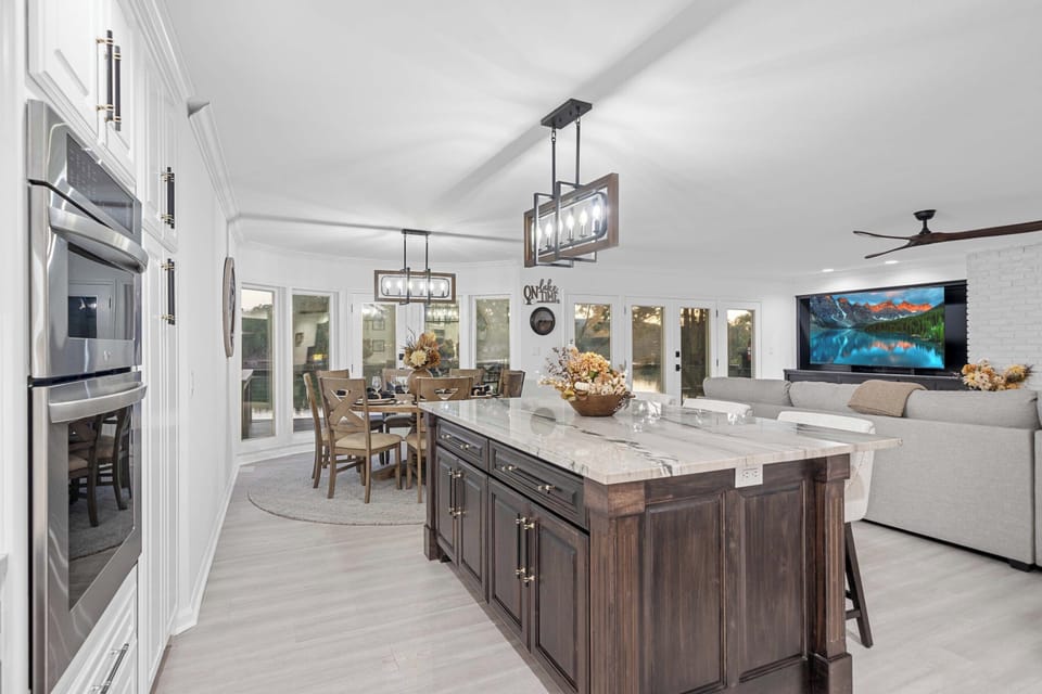 Enjoy seamless lake views from the kitchen, dining, and living areas, thanks to expansive glass windows that bring the outdoors in.