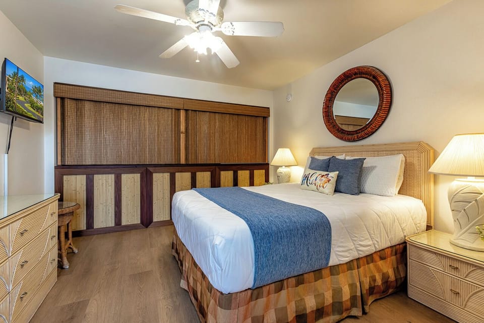 Sink into island-inspired comfort with a plush bed dressed in soft coastal tones, warm tropical accents, and gentle breezes from your overhead fan welcoming you home.