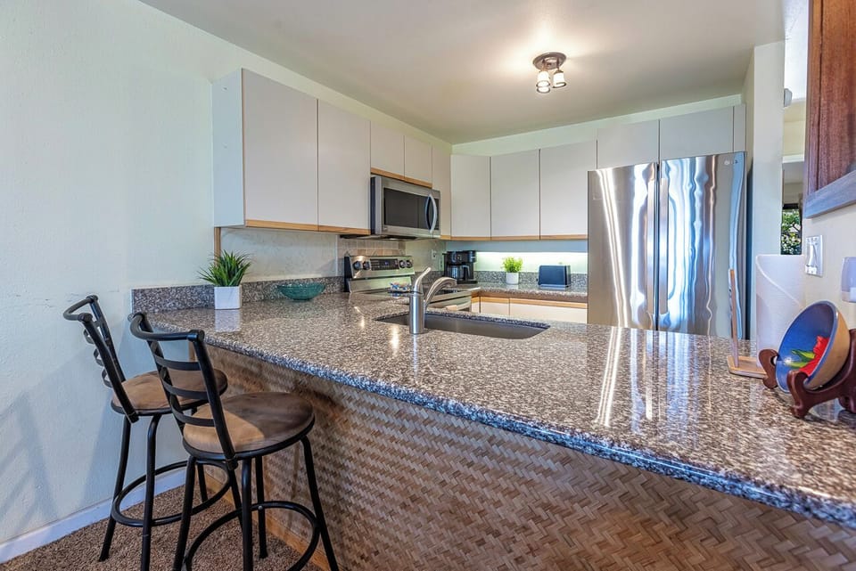 You'll love the sleek, fully equipped kitchen with gleaming granite counters, modern stainless appliances, and bar seating—perfect for prepping your favorite meals or sharing a casual breakfast before your day's adventure.