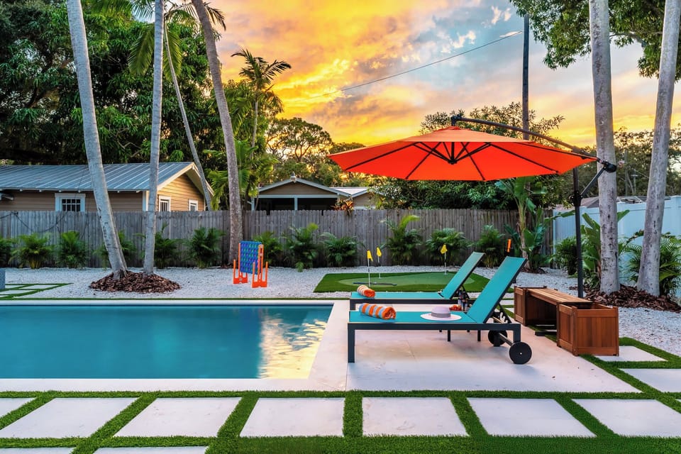 Our inviting inground pool sparkles under the warm glow of the sunset, with cozy loungers ready for relaxation. The perfect view after a memorable family beach day on Anna Maria Island.