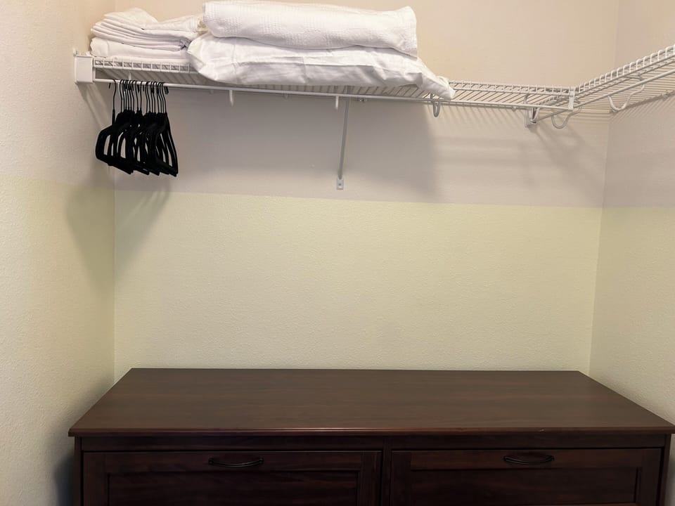 Walkin closet. Dresser, hangers, and linens.